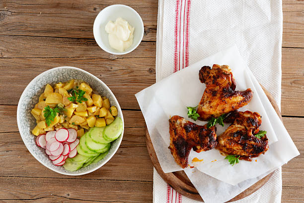 chicken wings on wooden plate, salad and mayonnaise - junk food stock pictures, royalty-free photos & images