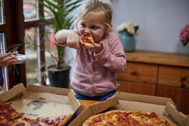 child eating a slice of pizza - junk food stock pictures, royalty-free photos & images