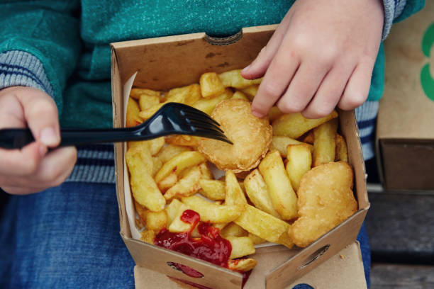 child eating a takeaway at the beach - junk food stock pictures, royalty-free photos & images