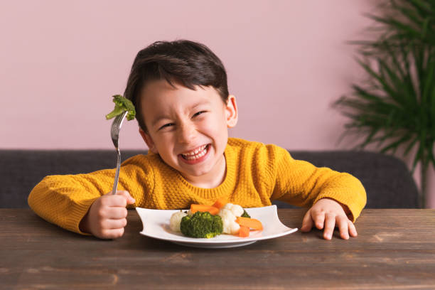 child is eating vegetables. - food stock pictures, royalty-free photos & images