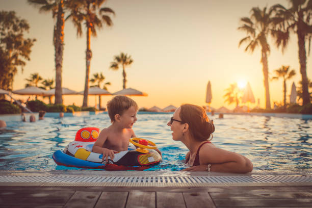 child with mother in swimming pool, holiday resort - travel stock pictures, royalty-free photos & images