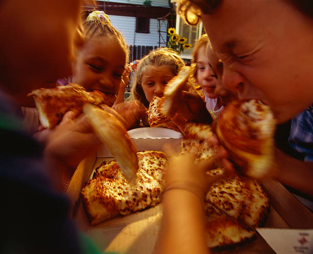 children eating pizza at a party - junk food stock pictures, royalty-free photos & images