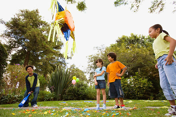 children hitting pinata at birthday party - garden decoration stock pictures, royalty-free photos & images