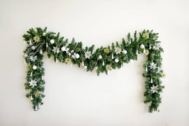 christmas garland with a christmas tree on a white wall. new year's decor. minimalism. festive background. - home decoration stock pictures, royalty-free photos & images