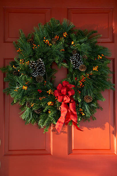 christmas pine wreath on red door - garden decoration stock pictures, royalty-free photos & images