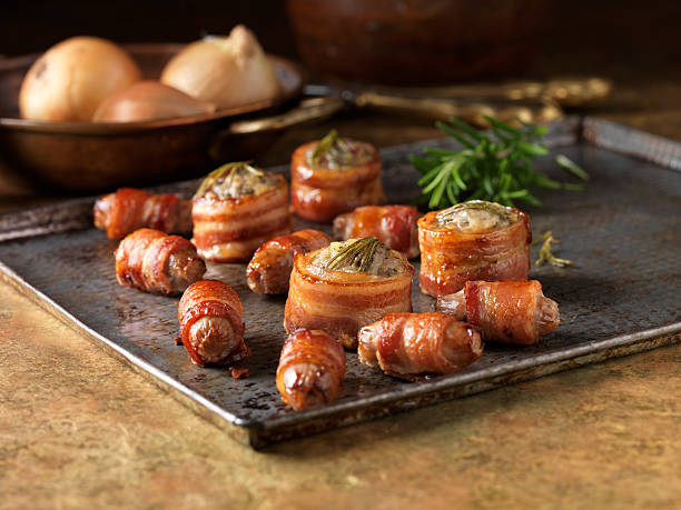 christmas snack of premium garnish selection. roast stuffed bacon rolls with rosemary, onions and pigs in blankets - food stock pictures, royalty-free photos & images