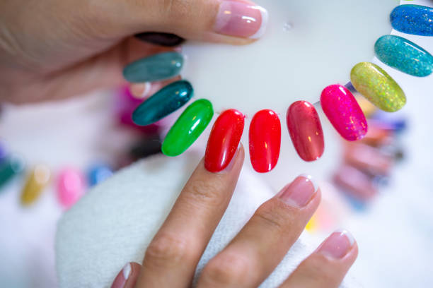 client choosing color of nail polish for manicure from palette colors. close up, only hands on white table visible. nail art, hands care, beauty concept. - nails art stock pictures, royalty-free photos & images