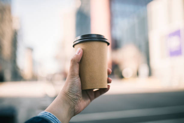 close-up of a businessman holding recycable takeaway coffee cup - junk food stock pictures, royalty-free photos & images
