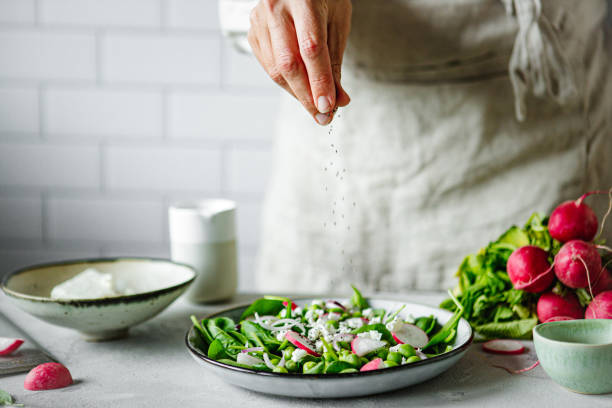 close-up of a woman making healthy summer green salad in kitchen - food stock pictures, royalty-free photos & images