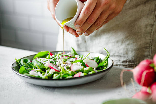 close-up of a woman preparing healthy summer green salad at home kitchen - food stock pictures, royalty-free photos & images