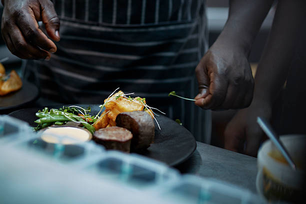 close-up of chef finishing dish in kitchen - food stock pictures, royalty-free photos & images