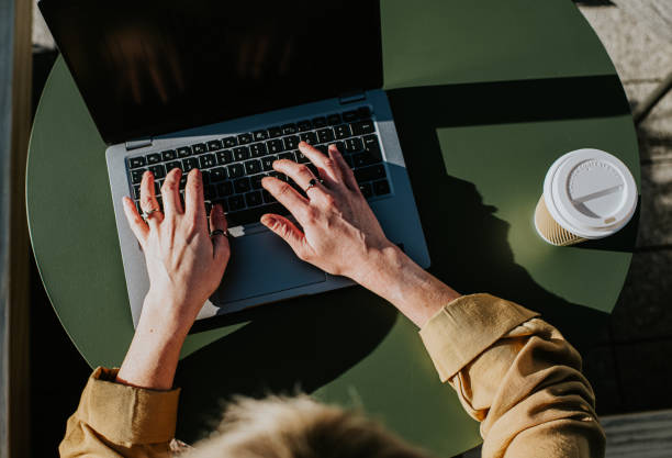 close-up of hands typing on a laptop computer - coffee stock pictures, royalty-free photos & images