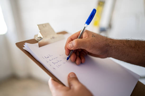close-up of man writing on clipboard at construction site - home decoration stock pictures, royalty-free photos & images