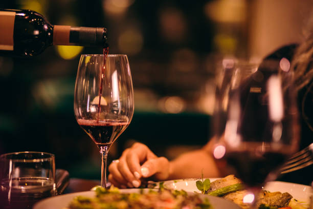 close-up of sommelier serving red wine at fine dining restaurant - food stock pictures, royalty-free photos & images