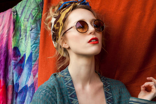 close-up of thoughtful stylish woman wearing sunglasses against fabric - fashion stock pictures, royalty-free photos & images