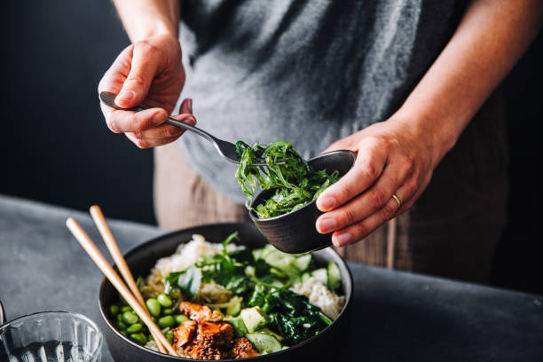 close-up of woman eating omega 3 rich salad - food stock pictures, royalty-free photos & images