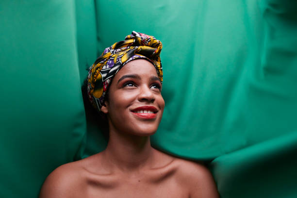 close-up of woman standing against green fabric - fashion stock pictures, royalty-free photos & images