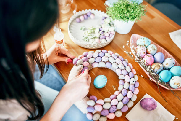 close-up of women's hands making a wreath of eggs for easter. - home decoration stock pictures, royalty-free photos & images