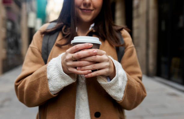 close-up of young woman with takeaway coffee in the city, barcelona, spain - junk food stock pictures, royalty-free photos & images