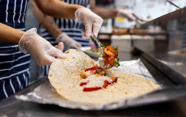 close-up on a waitress preparing quesadillas at a mexican restaurant - junk food stock pictures, royalty-free photos & images