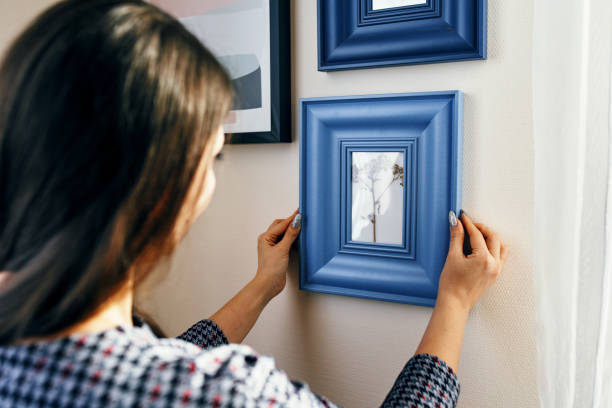 close-up young woman apartment, hangs frames on the walls. - home decoration stock pictures, royalty-free photos & images
