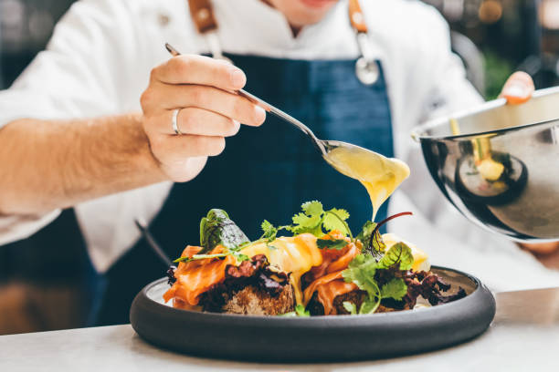 close up image of a chef preparing a gourmet dish. chef is decorating the plate just before the serving. - food stock pictures, royalty-free photos & images