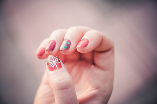 close up of artistic painted nails of a girl with gift symbol draw. - nails art stock pictures, royalty-free photos & images