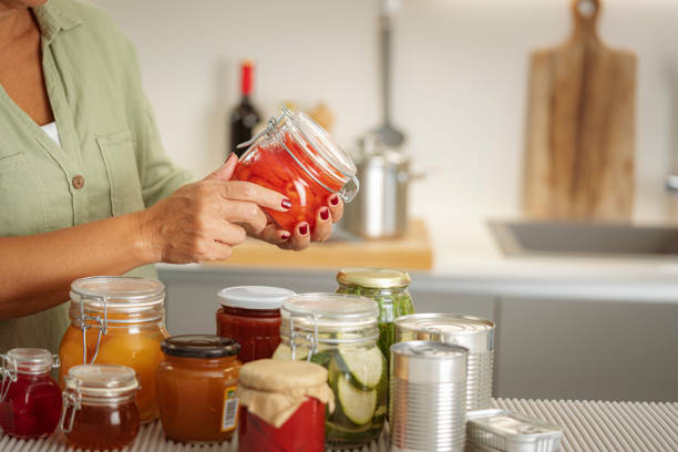 close up of woman,s hands holding a glass jar with preserved food - food stock pictures, royalty-free photos & images