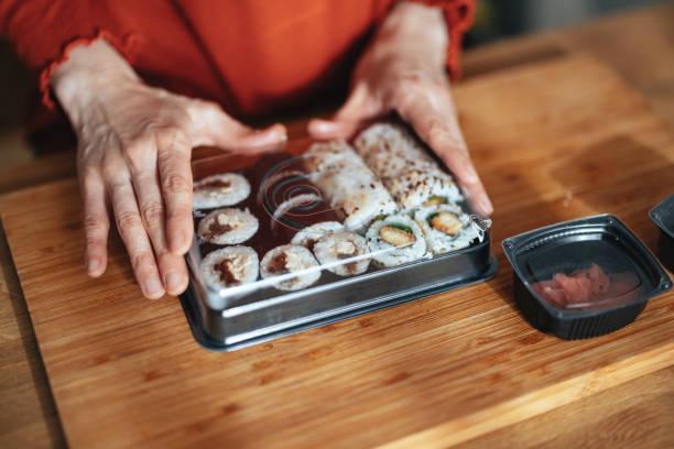 close up photo of woman hands packing takeaway food boxes - junk food stock pictures, royalty-free photos & images
