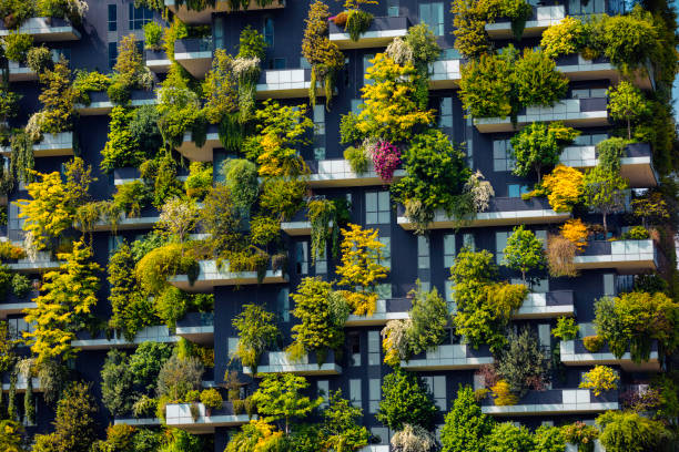 close up shot of modern skyscraper with green trees and colorful plants on balconies like a vertical forest in milano, italy - garden decoration stock pictures, royalty-free photos & images