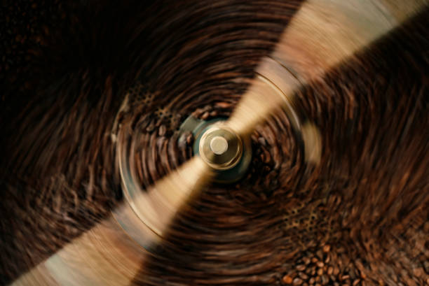 close up slow motion cooling batch spinning roasted coffee beans with a roasting machine - coffee stock pictures, royalty-free photos & images
