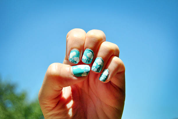 clouds and rain nail art on fingernail against blue sky - nails art stock pictures, royalty-free photos & images