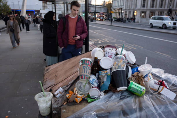 Coffee and soft drinks cups from some of the major take away food and drinks companies piled up on top of an overflowing street rubbish bin on 15th...