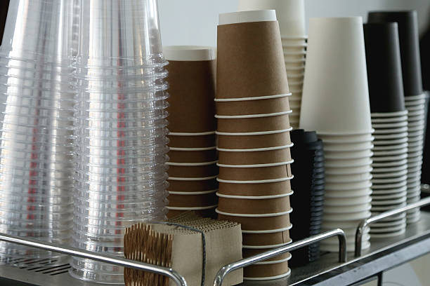 coffee corner with stack of brown paper disposable coffee cup and plastic glasses for mocktails - junk food stock pictures, royalty-free photos & images
