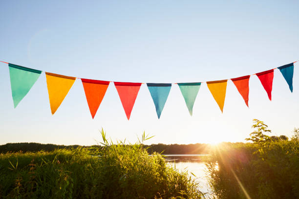 colorful pennant flags for party decoration at lake against sky - garden decoration stock pictures, royalty-free photos & images