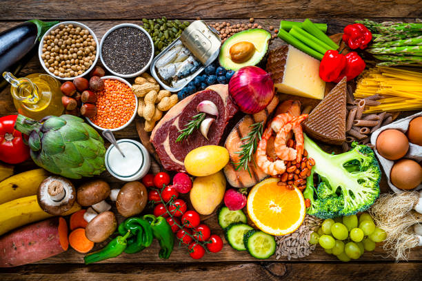 composition of healthy food aranged in a row on wooden table - food stock pictures, royalty-free photos & images