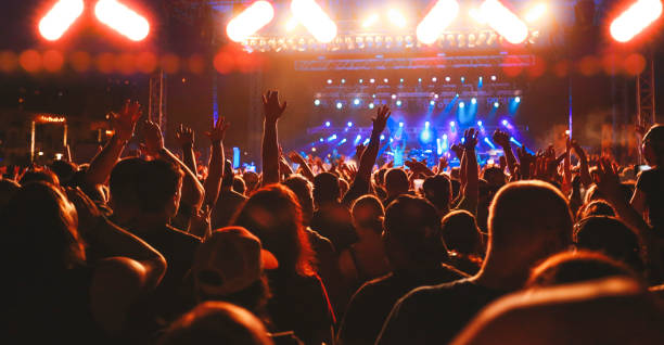 concert crowd arms raised, audience cheering, live music event - concert stock pictures, royalty-free photos & images