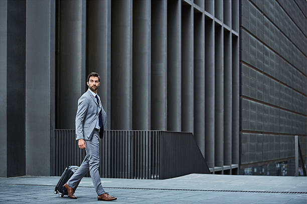 confident businessman with bag against building - travel stock pictures, royalty-free photos & images