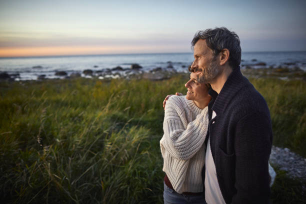 confident couple looking at view at the sea - travel stock pictures, royalty-free photos & images