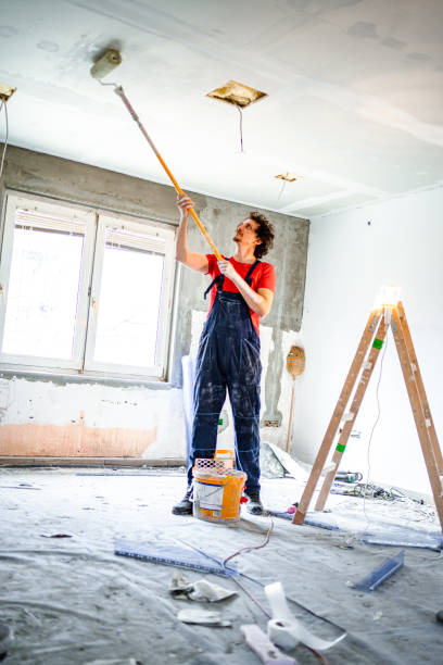 construction worker painting apartment ceiling with paint roller - home decoration stock pictures, royalty-free photos & images