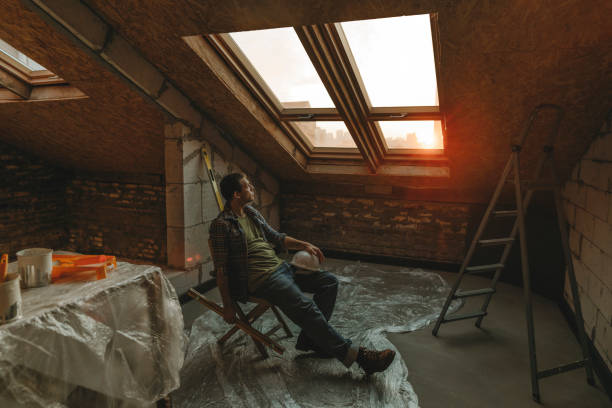construction worker sitting on table near window in room under renovation - home decoration stock pictures, royalty-free photos & images