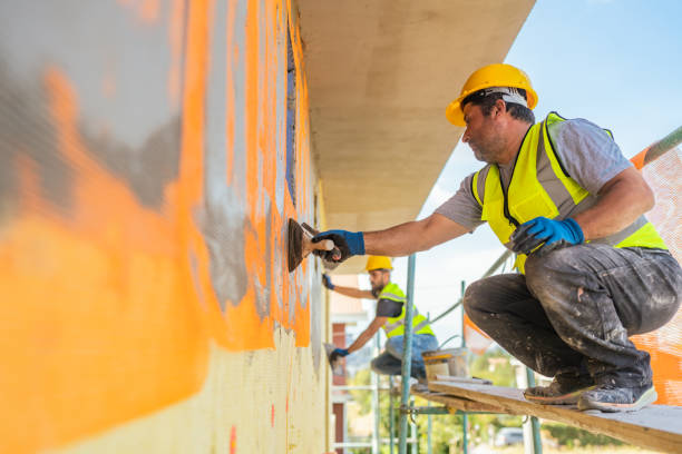 construction workers applying plaster on building facade - home decoration stockfoto's en -beelden