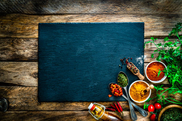 cooking background: multi colored spices, herbs and vegetables on rustic wooden table. copy space - food stock pictures, royalty-free photos & images