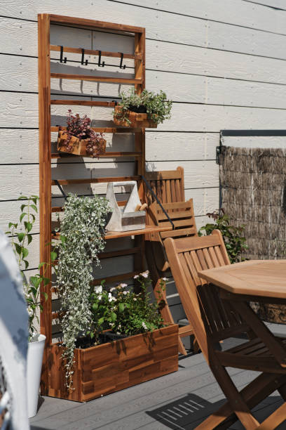 cosy space with garden furniture and plants on the rooftop terrace in sunny summer day - garden decoration stockfoto's en -beelden