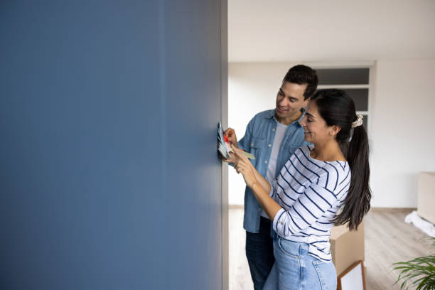couple choosing a color to paint the walls of their house - home decoration stock pictures, royalty-free photos & images