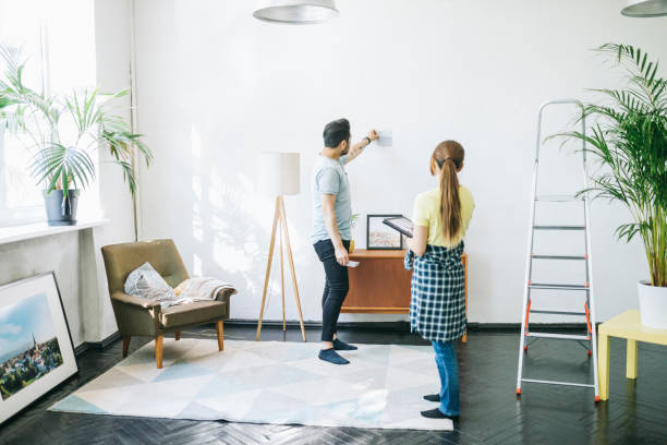 couple choosing the right color for their walls - home decoration stock pictures, royalty-free photos & images