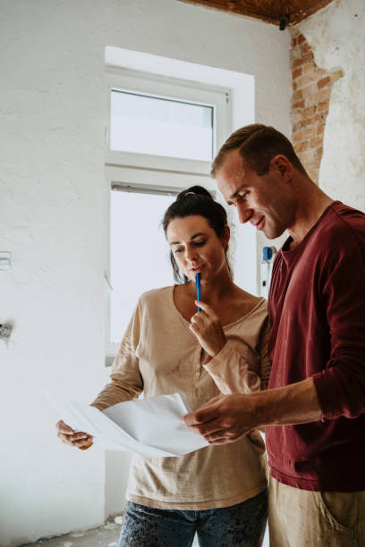 couple discussing over floor plan in room while renovating home - home decoration stock pictures, royalty-free photos & images