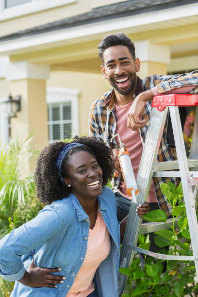 couple doing home repairs outside house - home decoration stock pictures, royalty-free photos & images