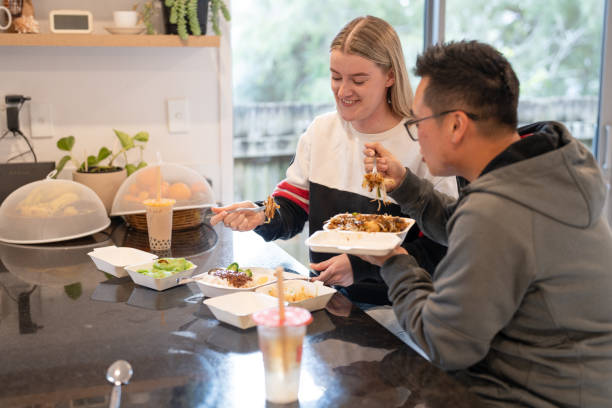 couple enjoying takeaway delivered food at home - junk food stock pictures, royalty-free photos & images