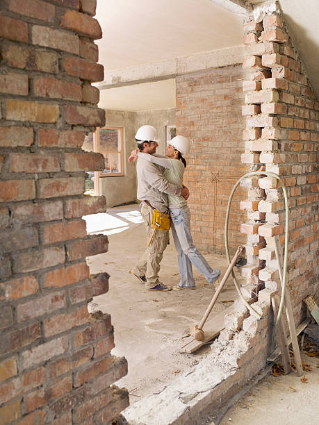 couple hugging in house under construction - home decoration stock pictures, royalty-free photos & images